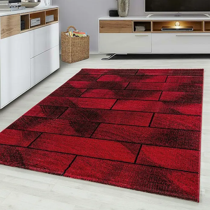 Kurzflorteppich Beta 1110Rot, 150 x 80 cm, 100 % Polypropylen - Ein moderner roter Teppich mit Ziegelmuster liegt in einem stilvollen Wohnzimmer. Perfekt, um jedem Raum Wärme und Charakter zu verleihen.
