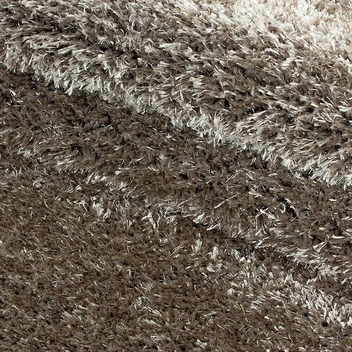 Hochflorteppich Brilliant 4200Taupe, 110 x 60 cm, 100% Polyester - Detailaufnahme eines weichen, braunen Shaggy-Teppichs mit helleren Akzenten, die eine luxuriöse Textur und Wärme ausstrahlen.