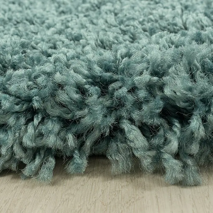 Hochflorteppich Sydney 3000Aqua, 170 x 120 cm, 100 % Polypropylen - Nahaufnahme eines zotteligen, aquafarbenen Teppichs, der eine weiche Textur und luxuriöse Haptik für Ihr Zuhause verspricht.