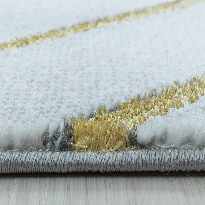 Kurzflorteppich Naxos 3811 - Gold, 200 x 140 cm, 80% Polypropylen, 20% Polyester - Nahaufnahme eines modernen Teppichs mit weißen und goldenen Akzenten, der Textur und Design hervorhebt.