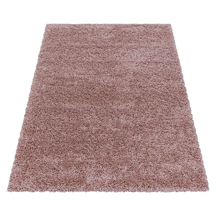 Hochflorteppich Sydney 3000Rose, 110 x 60 cm, 100% Polypropylen - Ein rechteckiger, lachsfarbener Shaggy-Teppich auf schwarzem Hintergrund. Der Teppich hat eine weiche Textur und lange Fasern.