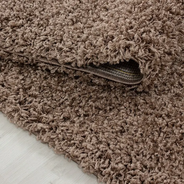Hochflorteppich Dream 4000Mocca, 130 x 65 cm, 100 % Polypropylen - Detailaufnahme eines braunen, gewellten Hochflorteppichs, der eine weiche und gemütliche Textur zeigt.
