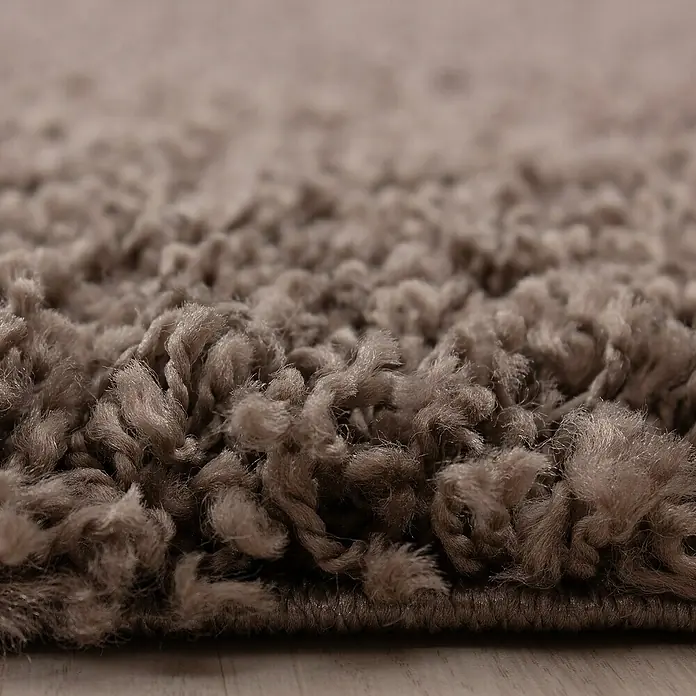 Hochflorteppich Dream 4000 - Taupe, 150 x 80 cm, 100% Polypropylen - Nahaufnahme eines beigen Shaggy-Teppichs, der eine weiche Textur und eine luxuriöse Haptik zeigt, perfekt für Komfort und Stil.