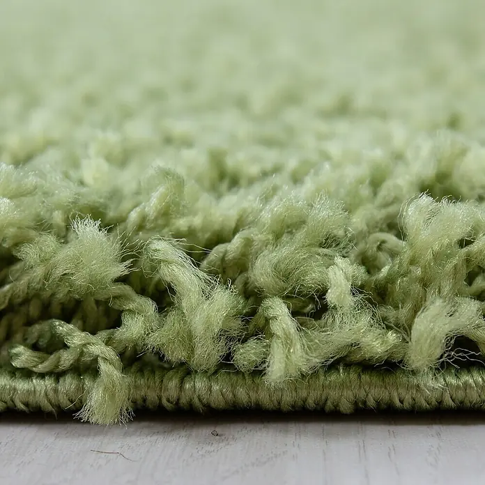Hochflorteppich Life 1500Grün, 250 x 80 cm, 100% Polypropylen - Nahaufnahme eines grünen Shaggy-Teppichs, der eine weiche, flauschige Textur und eine dichte Verarbeitung zeigt, ideal für Komfort und Stil im Wohnbereich.