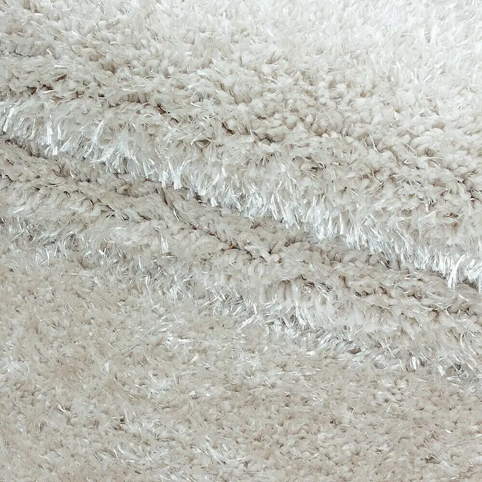 Hochflorteppich Brilliant 4200Natur, Durchmesser: 80 cm, 100% Polyester - Nahaufnahme eines flauschigen, weißen Teppichs mit einer weichen, zotteligen Textur, die ein luxuriöses und einladendes Gefühl vermittelt.