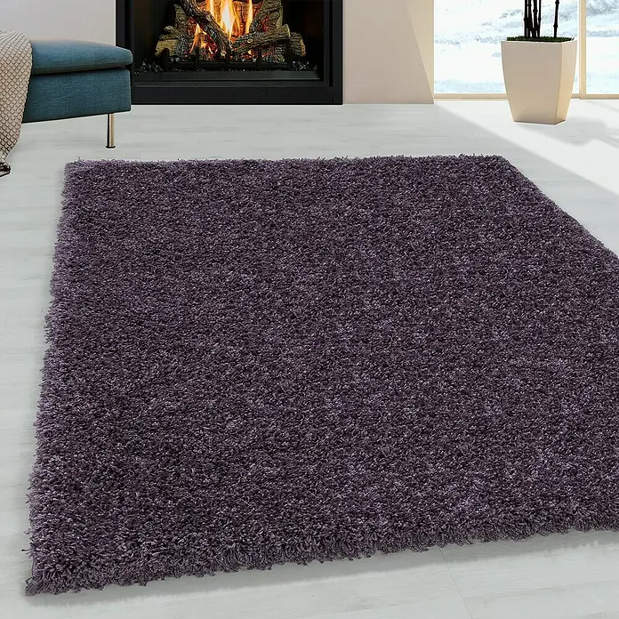 Hochflorteppich Sydney 3000Violett, 400 x 300 cm, 100% Polypropylen - Nahaufnahme eines lilafarbenen, flauschigen Teppichs im Wohnzimmer, der Wärme und Komfort ausstrahlt.