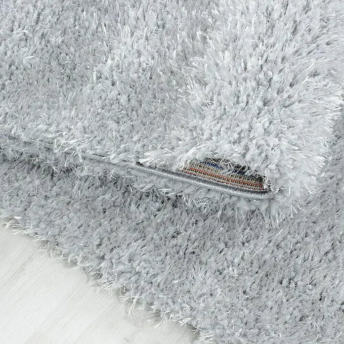 Hochflorteppich Brilliant 4200Silber, 230 x 160 cm, 100% Polyester - Detailaufnahme eines hochflorigen, silbernen Teppichs, der Weichheit und Komfort ausstrahlt. Perfekt, um jedem Raum eine luxuriöse Note zu verleihen.