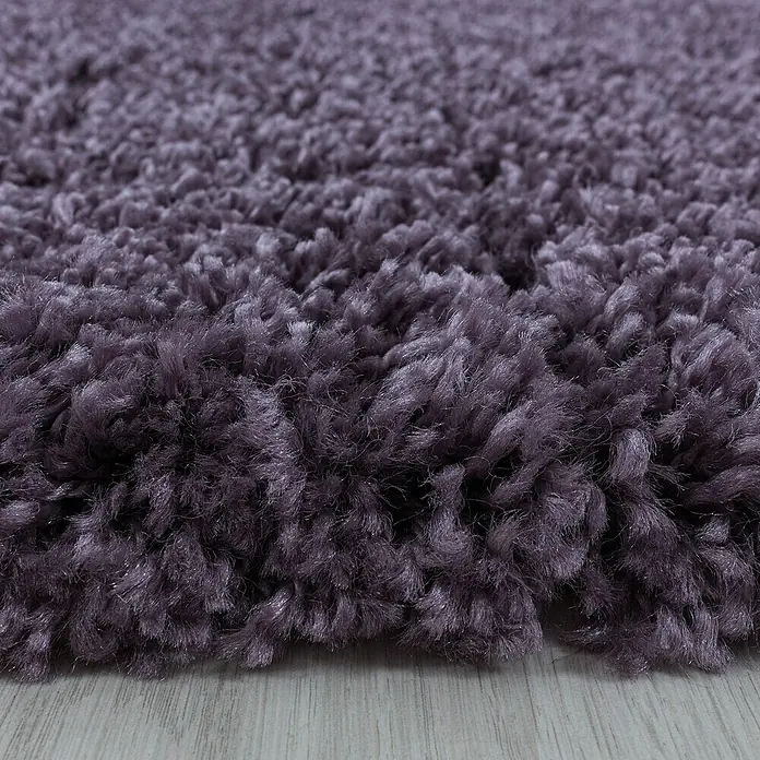 Hochflorteppich Sydney 3000Violett, 400 x 300 cm, 100% Polypropylen - Nahaufnahme eines flauschigen, lilafarbenen Hochflorteppichs, der Wärme und Komfort ausstrahlt.\n