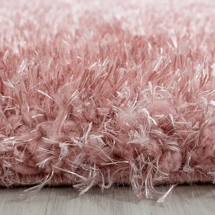 Hochflorteppich Brilliant 4200Rose, Durchmesser: 200 cm, 100% Polyester - Detailaufnahme eines rosafarbenen Shaggy-Teppichs mit langen Fasern, die eine weiche Textur zeigen.