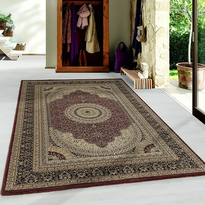 Kurzflorteppich Kashmir 2605Rot, 150 x 80 cm, 100 % Polypropylen - Ein detailreicher, gemusterter Teppich in Beige- und Rottönen liegt in einem hellen Raum. Sein klassisches Design macht ihn zum Hingucker.