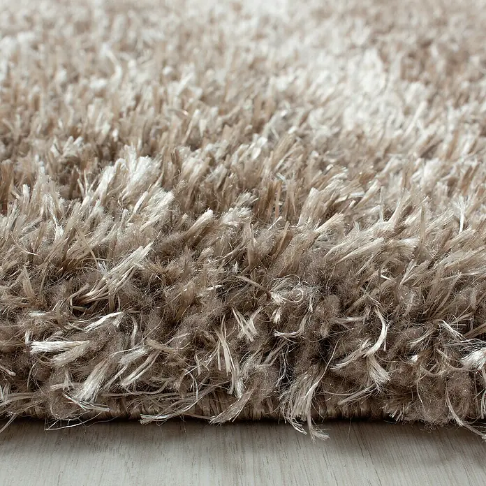 Hochflorteppich Brilliant 4200Taupe, 110 x 60 cm, 100% Polyester - Nahaufnahme eines beigen Shaggy-Teppichs mit langen, weichen Fasern, ideal für ein gemütliches Zuhause.