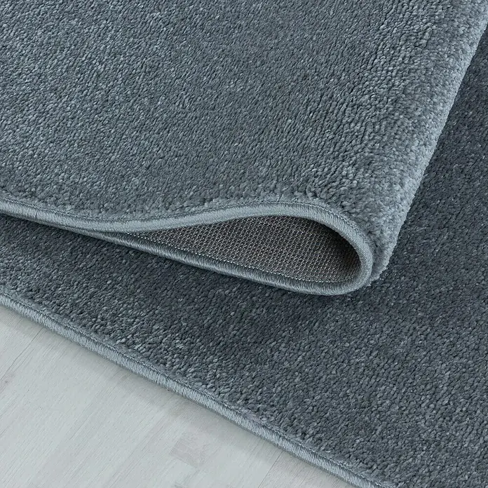 Hochflorteppich Rio 4600 - Silber, 150 x 80 cm, 100% Polypropylen - Nahaufnahme eines grauen Teppichs, der eine weiche Textur und eine umgeschlagene Ecke zeigt, die die Unterseite enthüllt.
