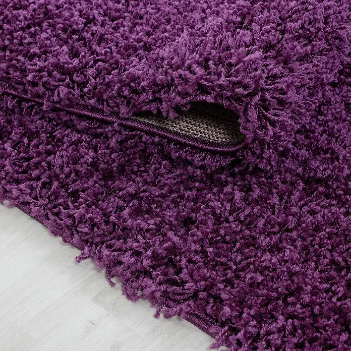 Hochflorteppich Life 1500 - Lila, 250 x 80 cm, 100% Polypropylen - Nahaufnahme eines lilafarbenen Shaggy-Teppichs mit hochfloriger Textur und sichtbarer Unterseite.
