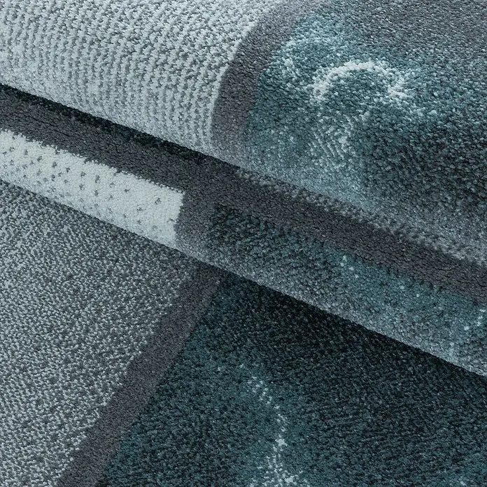 Kurzflorteppich Ottawa 4201Blau, 250 x 80 cm, 100% Polypropylen - Detailaufnahme eines mehrfarbigen Teppichs, der durch seine gewebte Textur und das Muster in Grau- und Blautönen besticht.