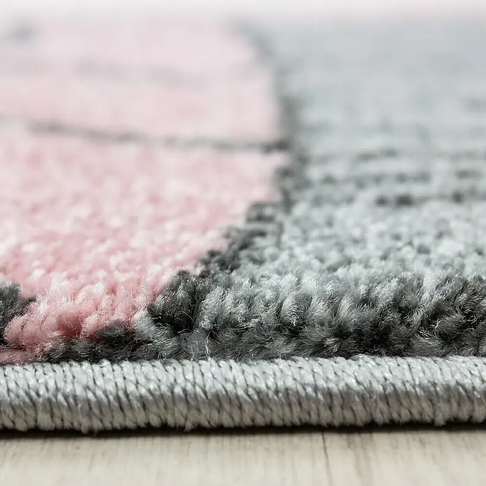Kinderteppich Kids 0580 - Pink, Durchmesser: 160 cm, 100% Polypropylen - Nahaufnahme eines flauschigen Teppichs mit rosa und grauen Farbflächen, der eine weiche Textur und ein modernes Design zeigt.