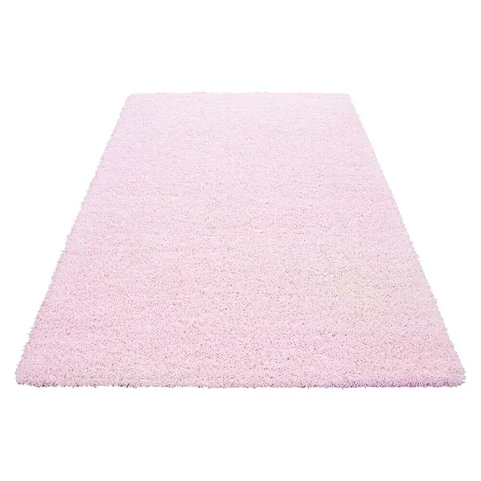 Hochflorteppich Life 1500 - Pink, 250 x 80 cm, 100% Polypropylen - Nahaufnahme eines rechteckigen, flauschigen, rosafarbenen Teppichs mit zotteliger Textur vor einem schwarzen Hintergrund.