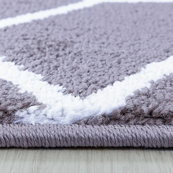 Kurzflorteppich Efor 3713Violett, 150 x 80 cm, 100 % Polypropylen - Nahaufnahme eines grauen Teppichs mit weißem Muster und gekettelten Kanten, der die Textur und das Design des Teppichs hervorhebt.