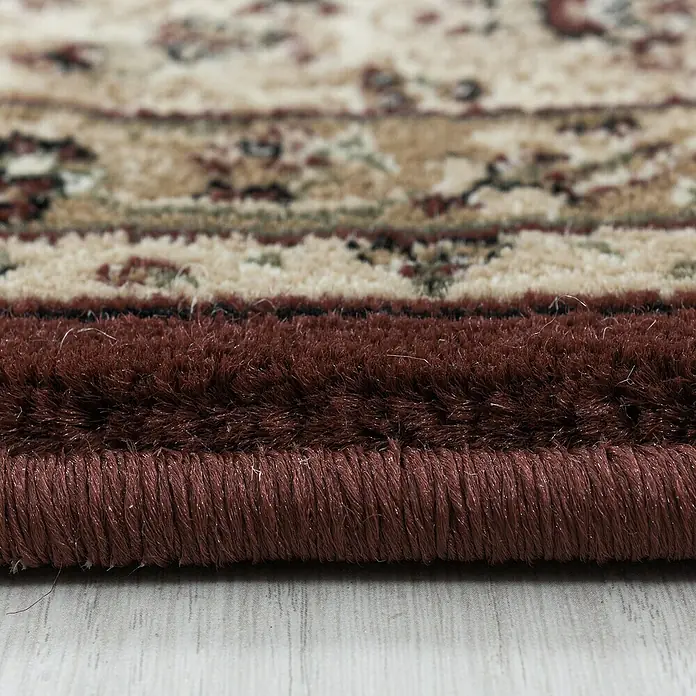 Kurzflorteppich Kashmir 2602 - Rot, 170 x 120 cm, 100 % Polypropylen - Detailaufnahme eines orientalischen Teppichs mit floralem Muster und bordeauxrotem Rand. Die Textur des Teppichs ist gut erkennbar.