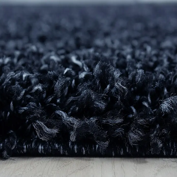 Hochflorteppich Life 1500Navy, 200 x 100 cm, 100% Polypropylen - Nahaufnahme eines dunklen, zotteligen Teppichs. Die Textur ist weich und einladend, ideal für ein gemütliches Zuhause.