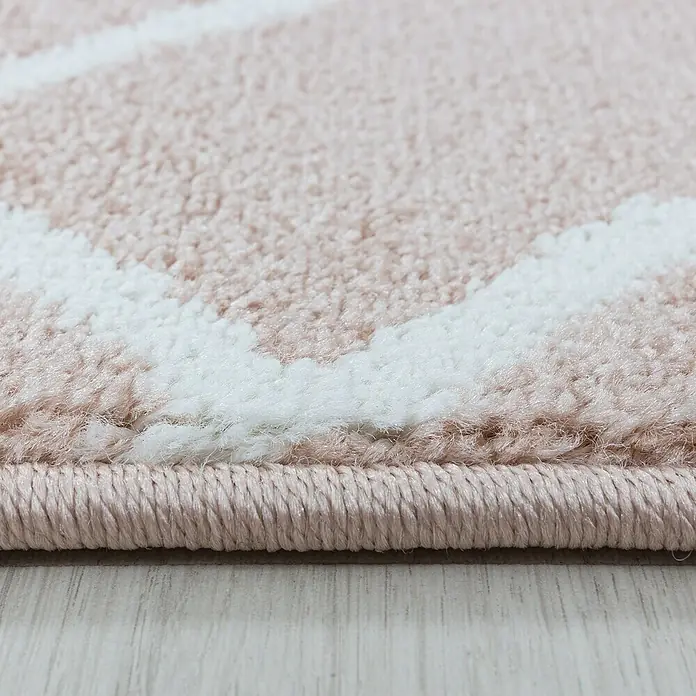 Kurzflorteppich Efor 3713Rose, 290 x 200 cm, 100% Polypropylen - Nahaufnahme eines Teppichs mit rosa und weißen geometrischen Mustern, der eine weiche Textur und hochwertige Verarbeitung zeigt.
