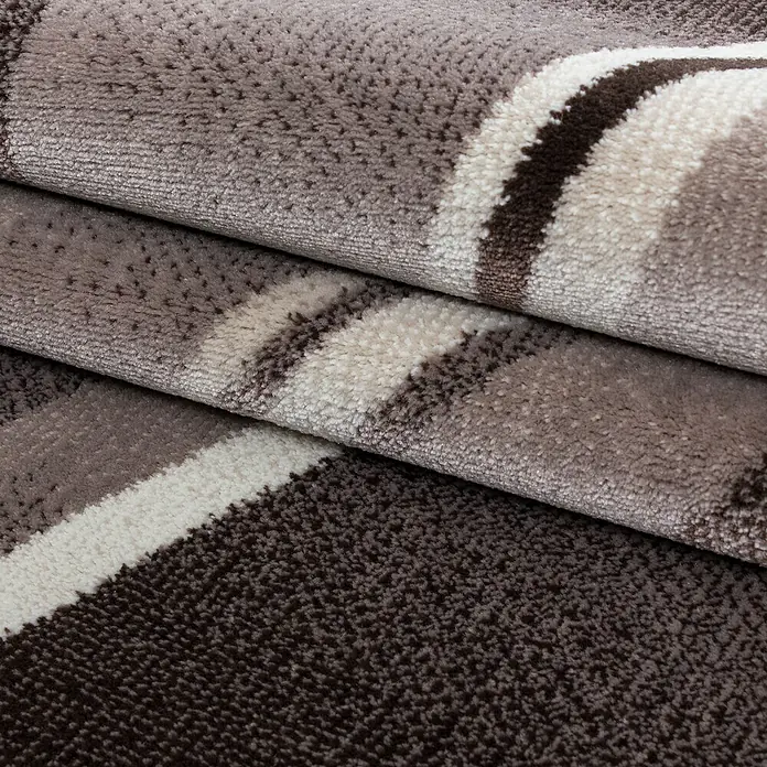 Kurzflorteppich Parma 9210Braun, 290 x 200 cm, 100% Polypropylen - Nahaufnahme eines Teppichs mit modernem Streifenmuster in Grau-, Braun- und Weißtönen, der eine weiche Textur und ein stilvolles Design zeigt.