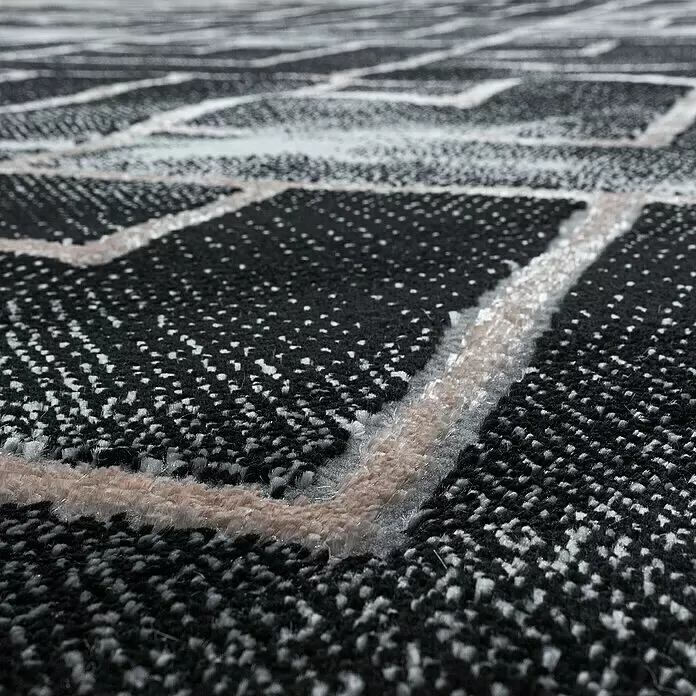 Kurzflorteppich Naxos 3814 - Bronze, 200 x 140 cm, 80% Polypropylen, 20% Polyester - Nahaufnahme eines schwarz-weiß-beigen Teppichs mit geometrischem Muster und weichem, strukturiertem Flor.