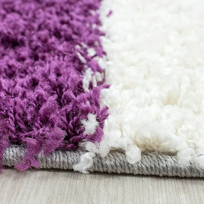 Hochflorteppich Life 1501Lila, 230 x 160 cm, 100% Polypropylen - Nahaufnahme eines zweifarbigen Teppichs in Lila und Weiß mit einem grauen Rand, der eine weiche und flauschige Textur zeigt.