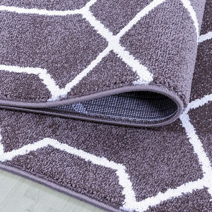 Kurzflorteppich Efor 3713Violett, 150 x 80 cm, 100 % Polypropylen - Detailansicht eines grauen Teppichs mit weißem geometrischen Muster und umgeschlagenem Rand.