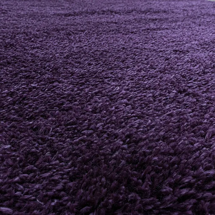 Hochflorteppich Fluffy 3500Lila, 340 x 240 cm, 100 % Polypropylen - Nahaufnahme eines violetten Teppichs mit hochflorigem Flor. Der Teppich hat eine weiche Textur und einen satten, tiefen Farbton.