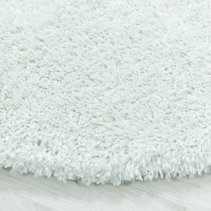 Hochflorteppich Fluffy 3500 - Weiß, 340 x 240 cm, 100 % Polypropylen - Nahaufnahme eines weichen, weißen Shaggy-Teppichs, der Textur und Komfort hervorhebt.\n
