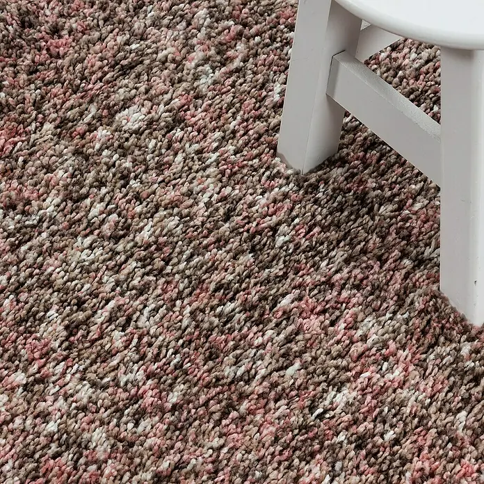 Hochflorteppich Enjoy - Rosa, Durchmesser: 80 cm, 100 % Polypropylen - Detailaufnahme eines mehrfarbigen Teppichs mit einem weißen Stuhlbein im Bild.