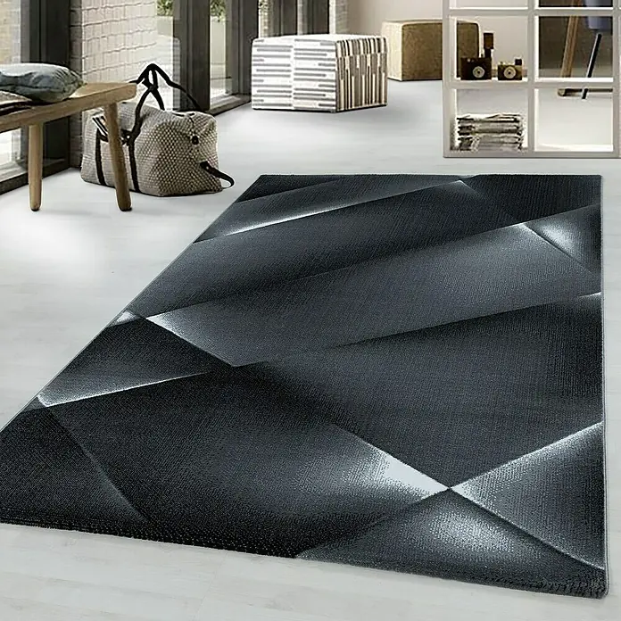 Kurzflorteppich Costa 3527Schwarz, 200 x 140 cm, 100% Polypropylen - Ein rechteckiger Teppich in Grau mit abstraktem 3D-Design liegt in einem modern eingerichteten Raum.