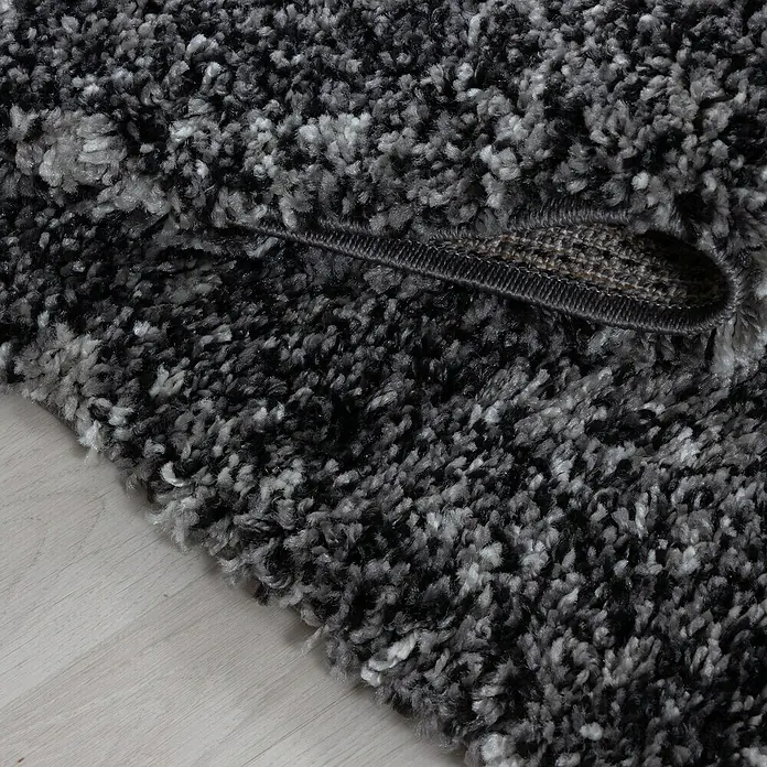 Hochflorteppich Enjoy 4500 - Anthrazit, 230 x 160 cm, 100 % Polypropylen - Detailaufnahme eines hochflorigen, schwarz-grauen Shaggy-Teppichs, der Weichheit und Komfort ausstrahlt.