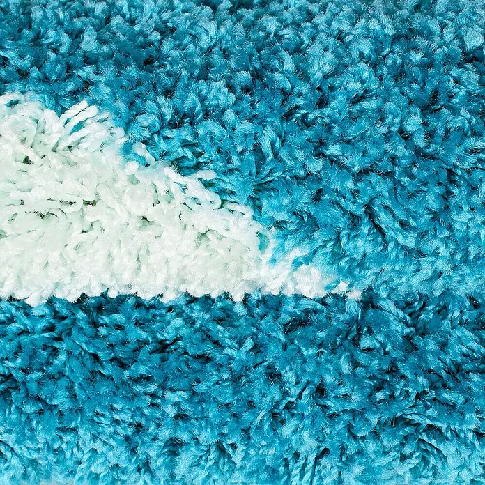Kinderteppich Fun 6001 - Türkis, Durchmesser: 120 cm, 100% Polypropylen - Nahaufnahme eines blauen Teppichs mit einem breiten, weißen Streifen. Die Textur ist flauschig und lädt zum Anfassen ein.
