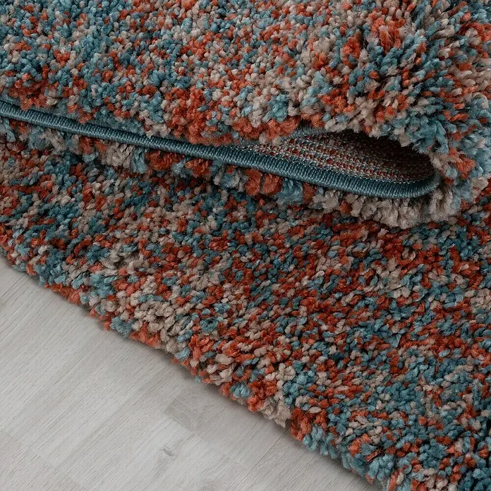 Hochflorteppich Enjoy 4500Terrakotta, 170 x 120 cm, 100 % Polypropylen - Nahaufnahme eines farbenfrohen, mehrfarbigen Shaggy-Teppichs mit blauen, orangefarbenen und beigen Farbtönen für ein gemütliches Ambiente.