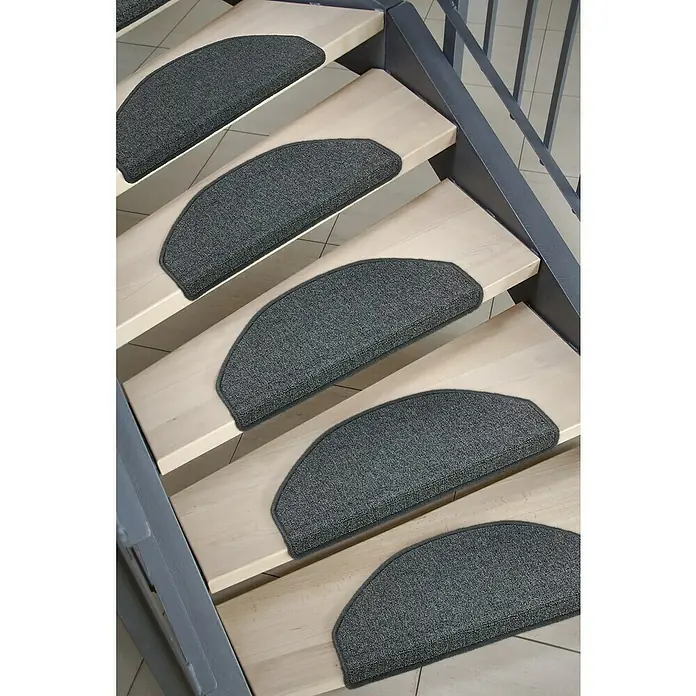 Astra Stufenmatte Fox - 28 x 65 cm, 100 % Polypropylen, Schwarz - Bild einer Treppe mit halbmondförmigen, grauen Teppichstufenauflagen.
