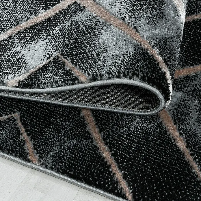 Kurzflorteppich Naxos 3812 - Bronze, 200 x 140 cm, 80% Polypropylen, 20% Polyester - Nahaufnahme eines modernen Teppichs mit geometrischem Muster in Schwarz-, Grau- und Rosatönen.