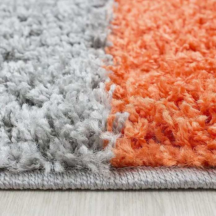 Hochflorteppich Life 1501 - Terra, 110 x 60 cm, 100 % Polypropylen - Nahaufnahme eines zweifarbigen, hochflorigen Teppichs in Grau und Orange, der eine weiche und komfortable Textur zeigt.