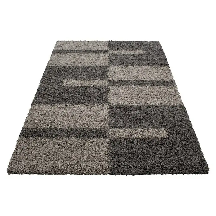 Hochflorteppich Gala 2505 - Taupe, 340 x 240 cm, 100% Polypropylen - Detailaufnahme eines modernen, rechteckigen Teppichs mit einem geometrischen Muster in Grau- und Brauntönen vor einem schwarzen Hintergrund.