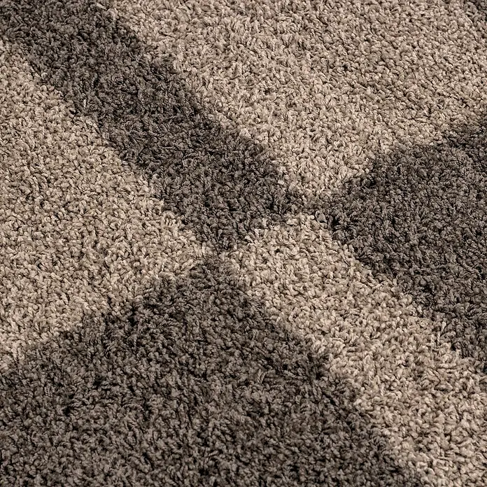Hochflorteppich Gala 2505 - Taupe, 340 x 240 cm, 100% Polypropylen - Nahaufnahme eines getufteten Teppichs mit einem schattigen Muster, der die Textur und die neutralen Farbtöne hervorhebt.