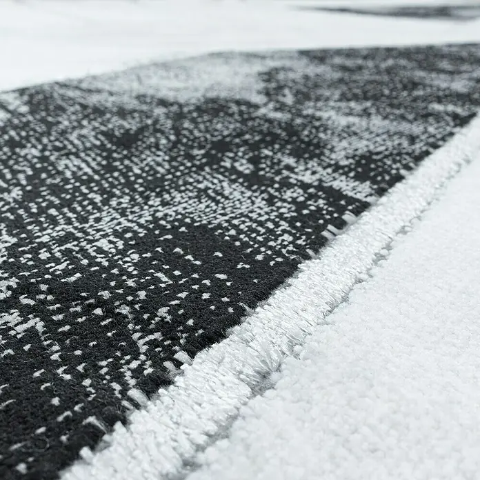 Kurzflorteppich Naxos 3817Silber, 150 x 80 cm, 80% Polypropylen, 20% Polyester - Nahaufnahme eines modernen Teppichs mit abstraktem Schwarz-Weiß-Muster und sauberer, heller Umrandung, der Textur und Design hervorhebt.