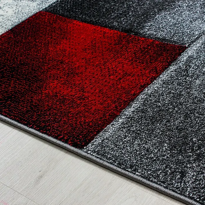 Kurzflorteppich Hawaii 1710 - Rot, 300 x 80 cm, 100% Polypropylen - Nahaufnahme eines modernen Teppichs mit geometrischem Muster in Rot-, Grau- und Schwarztönen, der eine stilvolle Textur und Design zeigt.