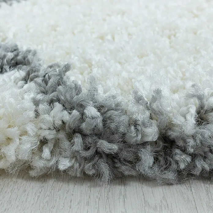 Hochflorteppich Salsa 3201 - Cream, 250 x 80 cm, 100% Polypropylen - Nahaufnahme eines weißen und grauen Teppichs mit hohem Flor. Der Teppich hat eine weiche Textur und ein attraktives Design.