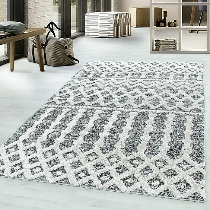 Hochflorteppich Pisa 4710Grau, 200 x 140 cm, 100 % Polypropylen - Ein rechteckiger, grauer Teppich mit geometrischen Mustern liegt in einem hellen Raum.