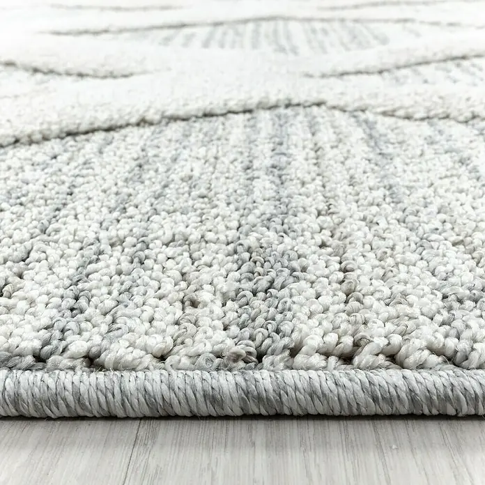 Hochflorteppich Pisa 4703Grau, Durchmesser: 80 cm, 100% Polypropylen - Nahaufnahme eines hellgrauen Teppichs mit geometrischem Muster und schattierten Details, der eine weiche Textur und moderne Ästhetik zeigt.