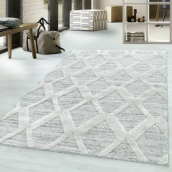Hochflorteppich Pisa 4703Grau, 290 x 200 cm, 100% Polypropylen - Nahaufnahme eines modernen, grauen Teppichs mit einem hellen, geometrischen Muster. Er verleiht jedem Raum ein stilvolles Ambiente.