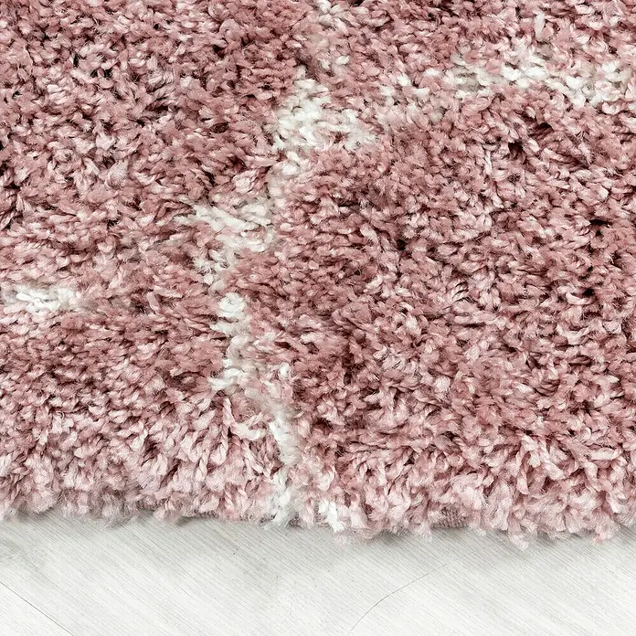 Hochflorteppich Salsa 3201Rose, 110 x 60 cm, 100% Polypropylen - Nahaufnahme eines rosa Shaggy-Teppichs mit weißen Akzenten, der eine weiche und luxuriöse Textur für Wohnräume bietet.