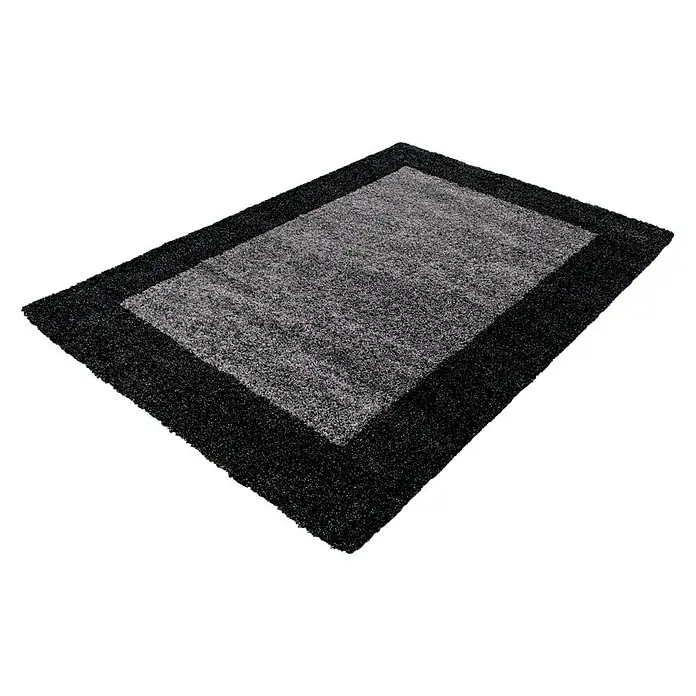 Hochflorteppich Life 1503 - Anthrazit, 110 x 60 cm, 100 % Polypropylen - Ein rechteckiger Teppich mit einem dunklen Rand und einem helleren, grauen Mittelteil liegt auf einem schwarzen Untergrund.