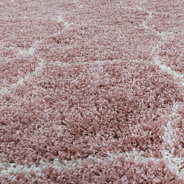 Hochflorteppich Salsa 3201Rose, Durchmesser: 160 cm, 100% Polypropylen - Nahaufnahme eines weichen, rosa Teppichs mit weißem geometrischem Muster, der Komfort und Stil vereint.