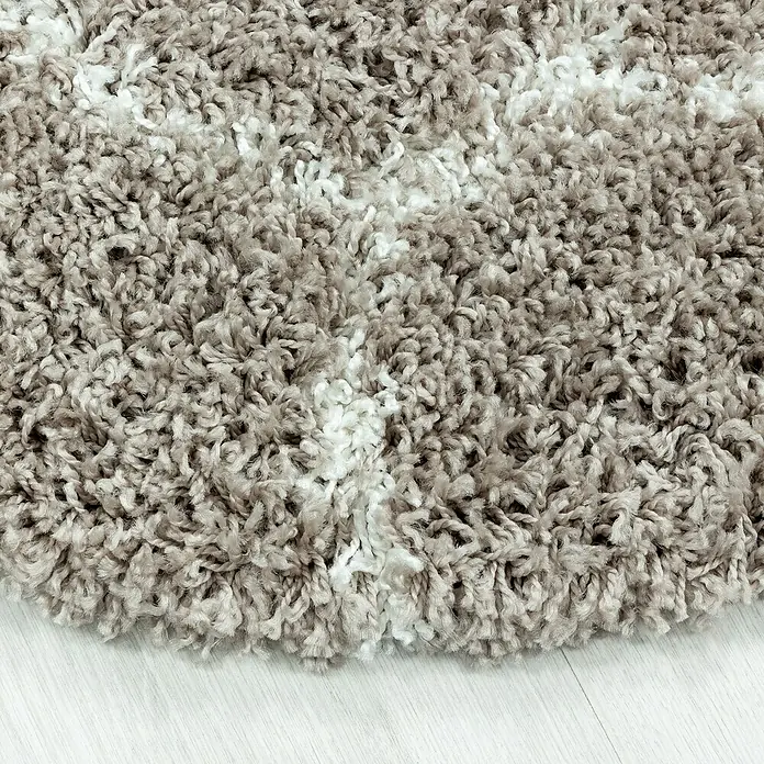 Hochflorteppich Salsa 3201Beige, Durchmesser: 120 cm, 100% Polypropylen - Nahaufnahme eines runden, beigen und weißen Zottelteppichs, der eine weiche Textur und ein gemütliches Aussehen zeigt.